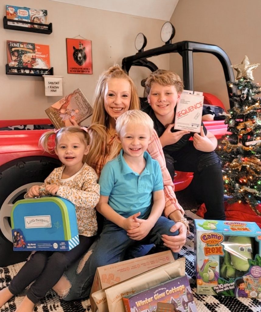 mother and three children holding assortment of brain-building gifts for kids