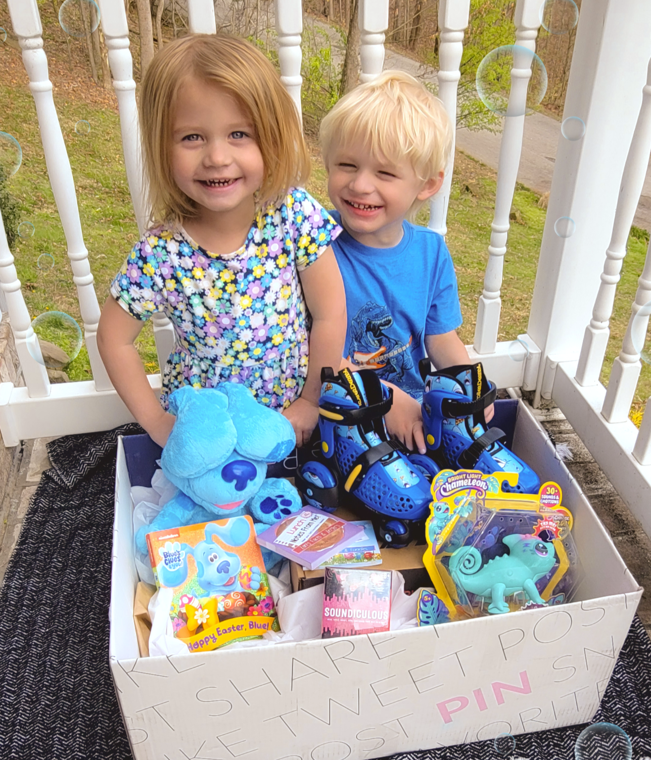 two kids sitting behind large box of fun kid activities toys