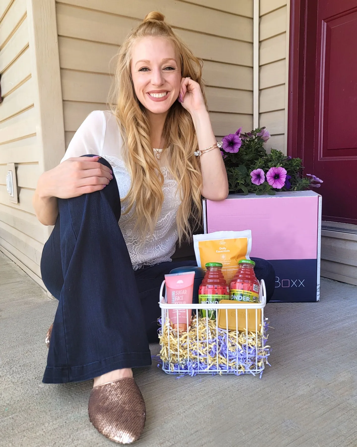 Blonde girl sitting next to basket of products.