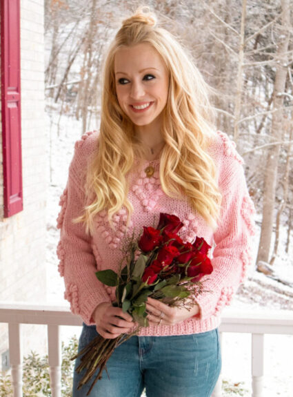 blonde girl with pink sweater and red roses